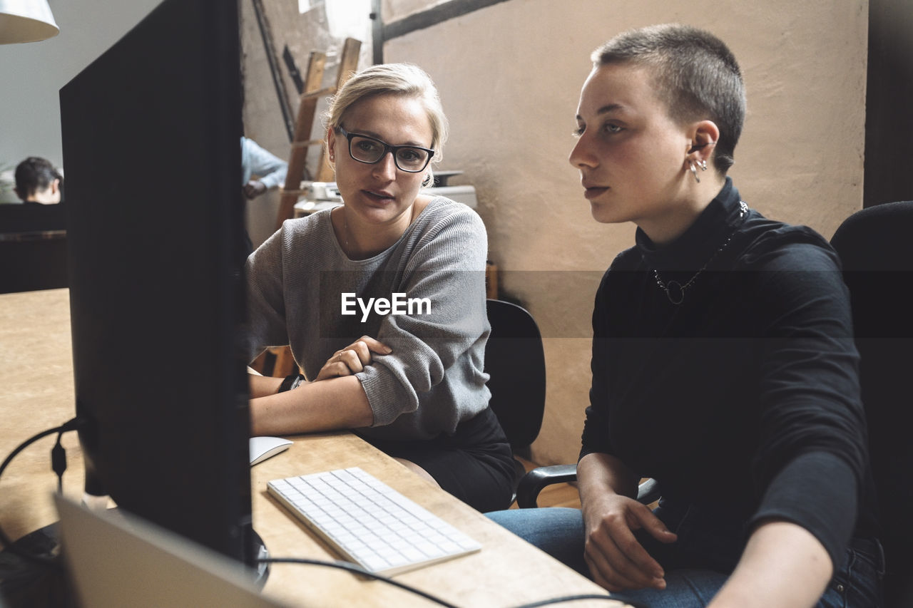 Female entrepreneurs discussing while sitting at workplace