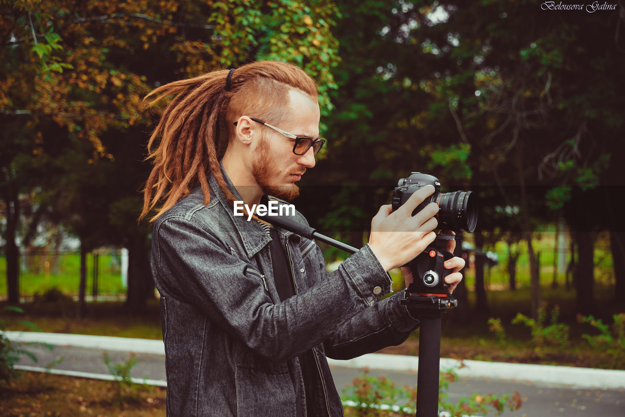 WOMAN PHOTOGRAPHING WITH CAMERA