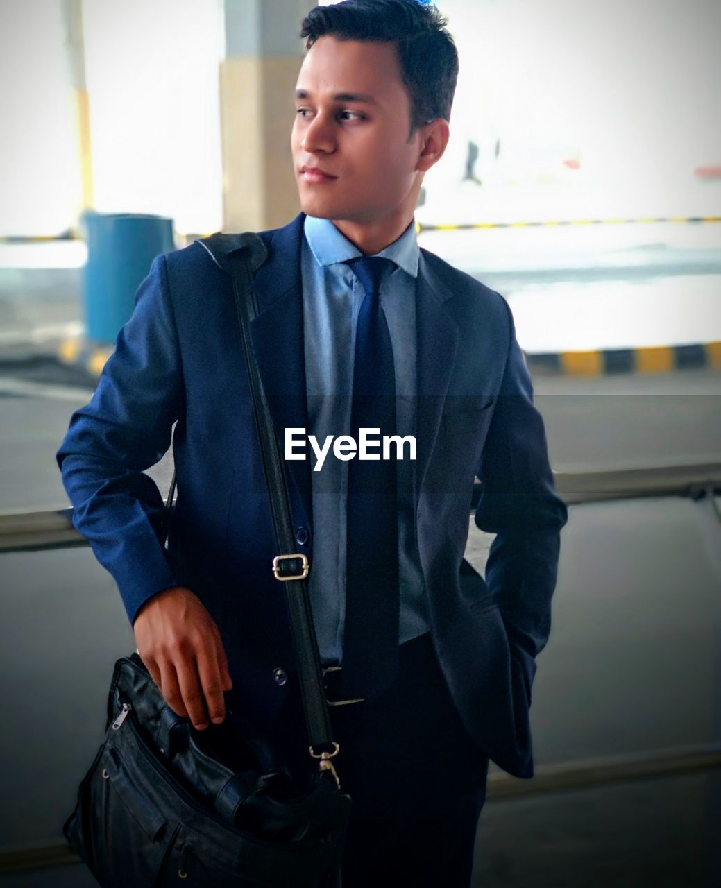 Young businessman looking away while standing on street