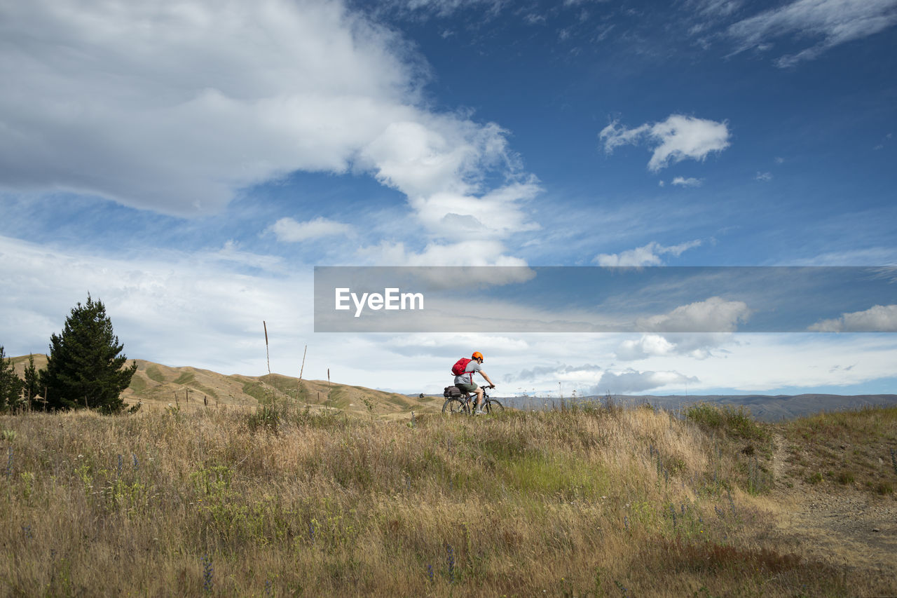 PEOPLE RIDING BICYCLE ON FIELD