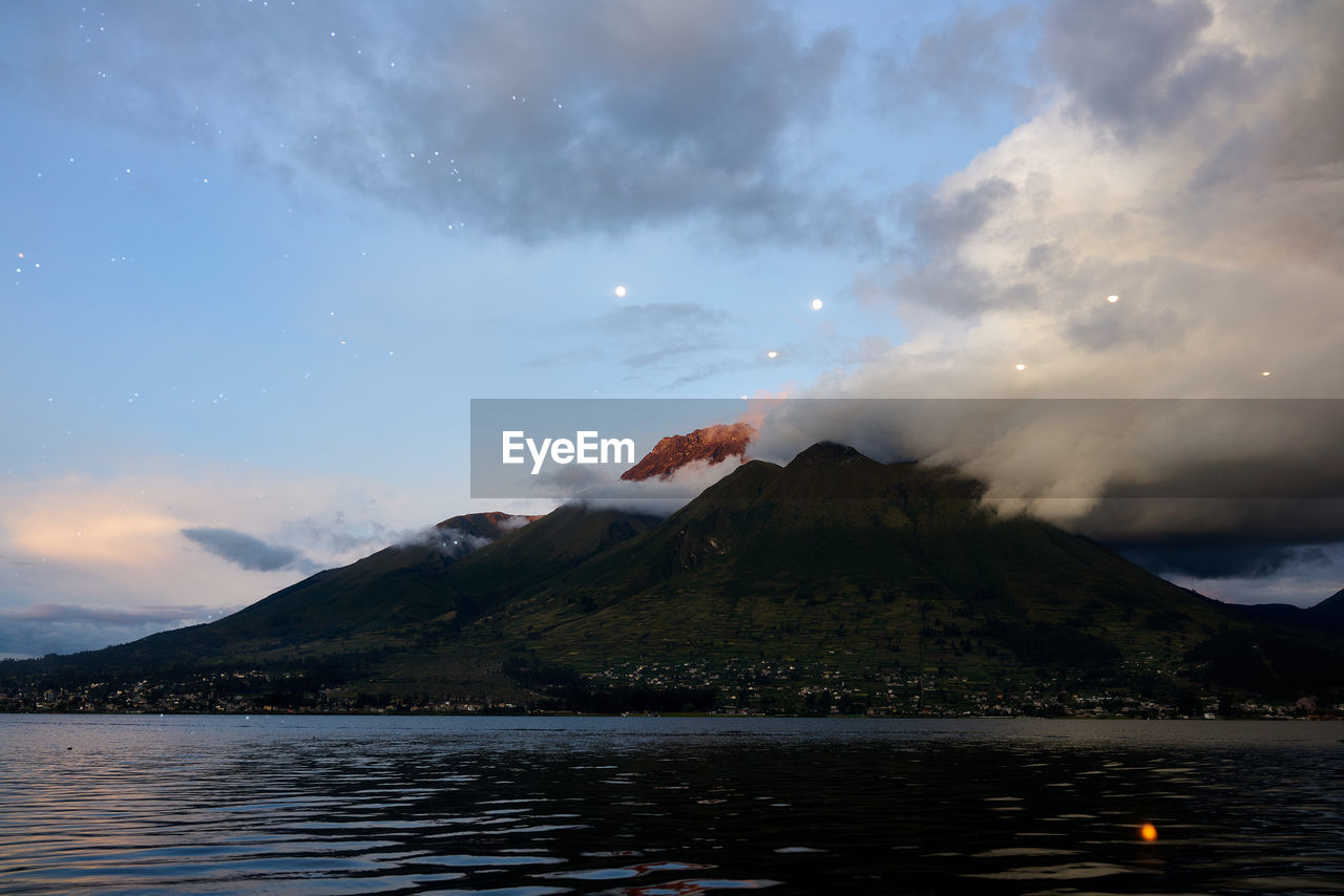 Scenic view of lake by mountains against sky