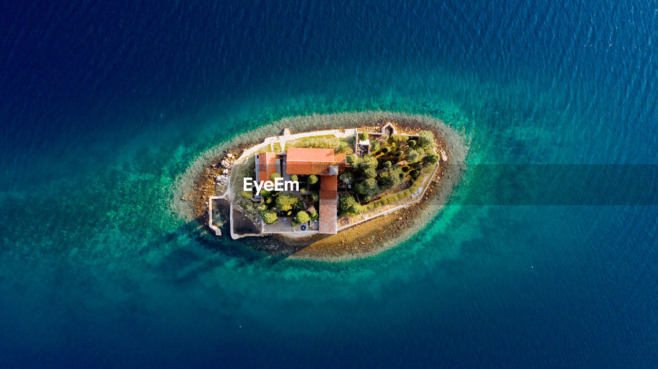 Aerial view of house surrounded by sea