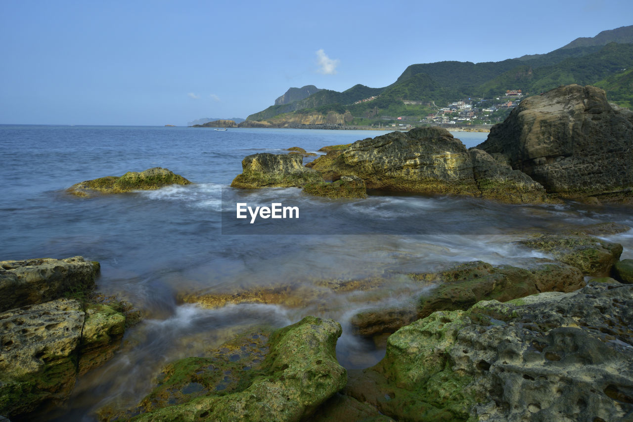 SCENIC VIEW OF ROCKS ON SHORE AGAINST SKY