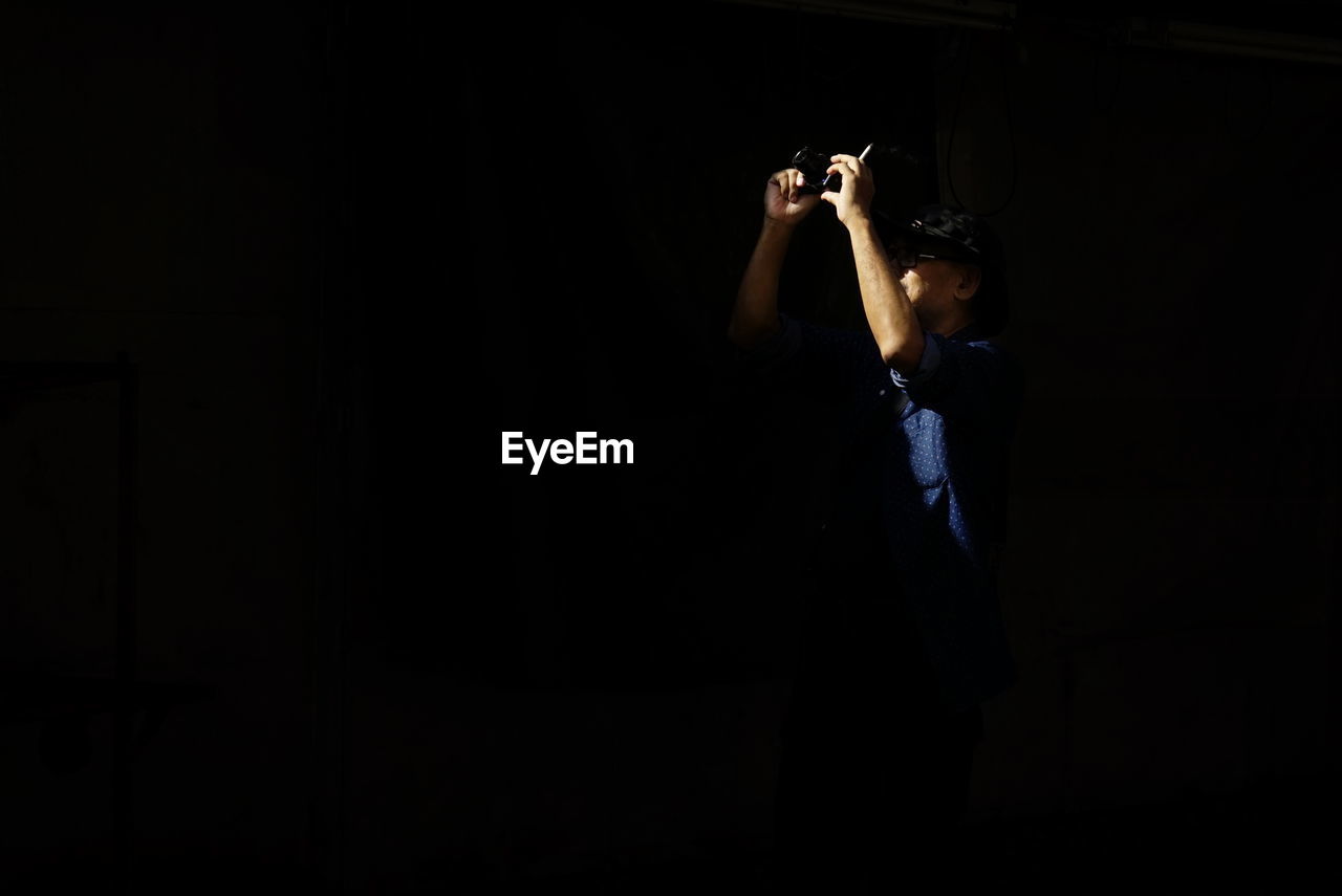 SIDE VIEW OF A BOY LOOKING AT DARK ROOM