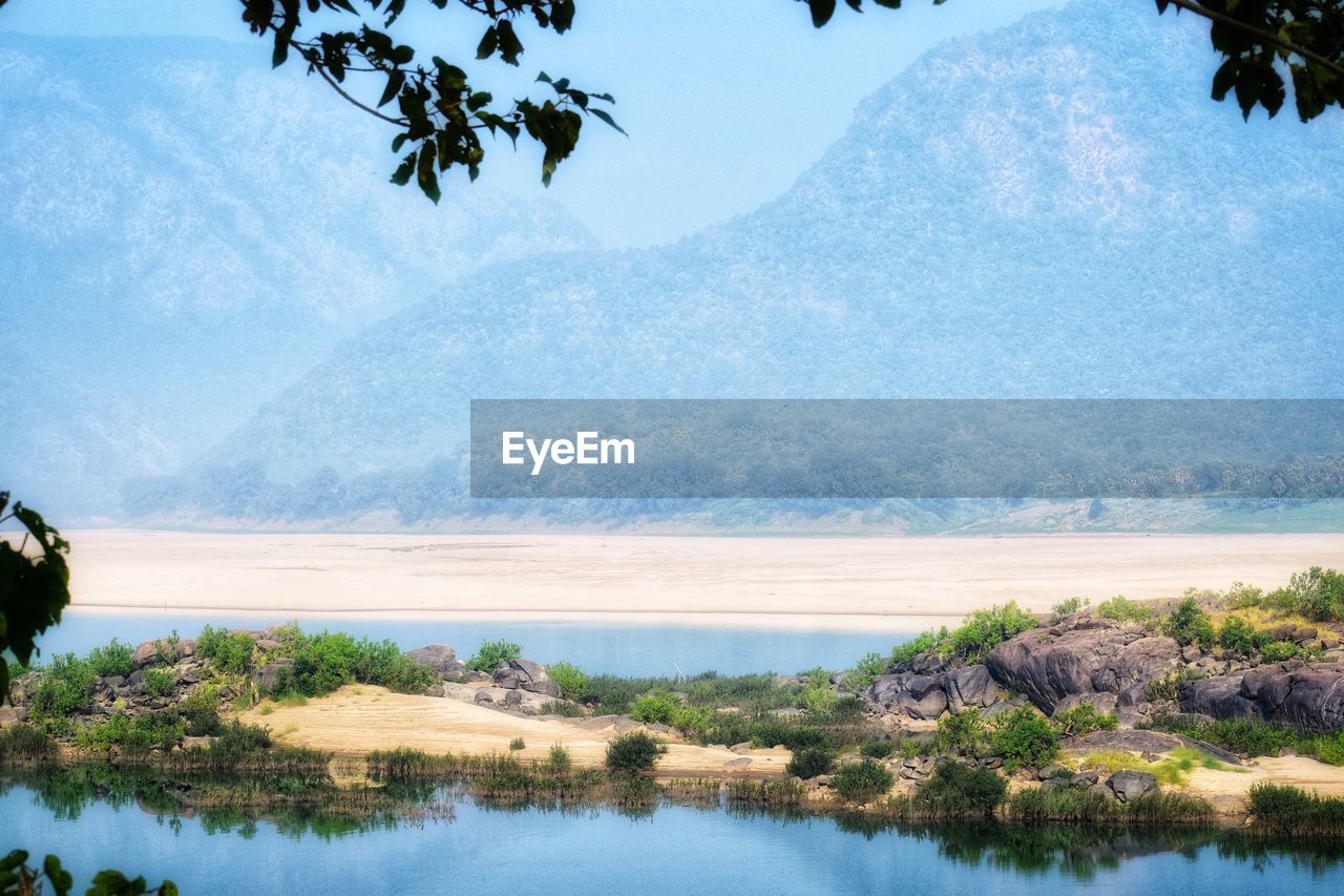 Scenic view of lake and mountains against sky