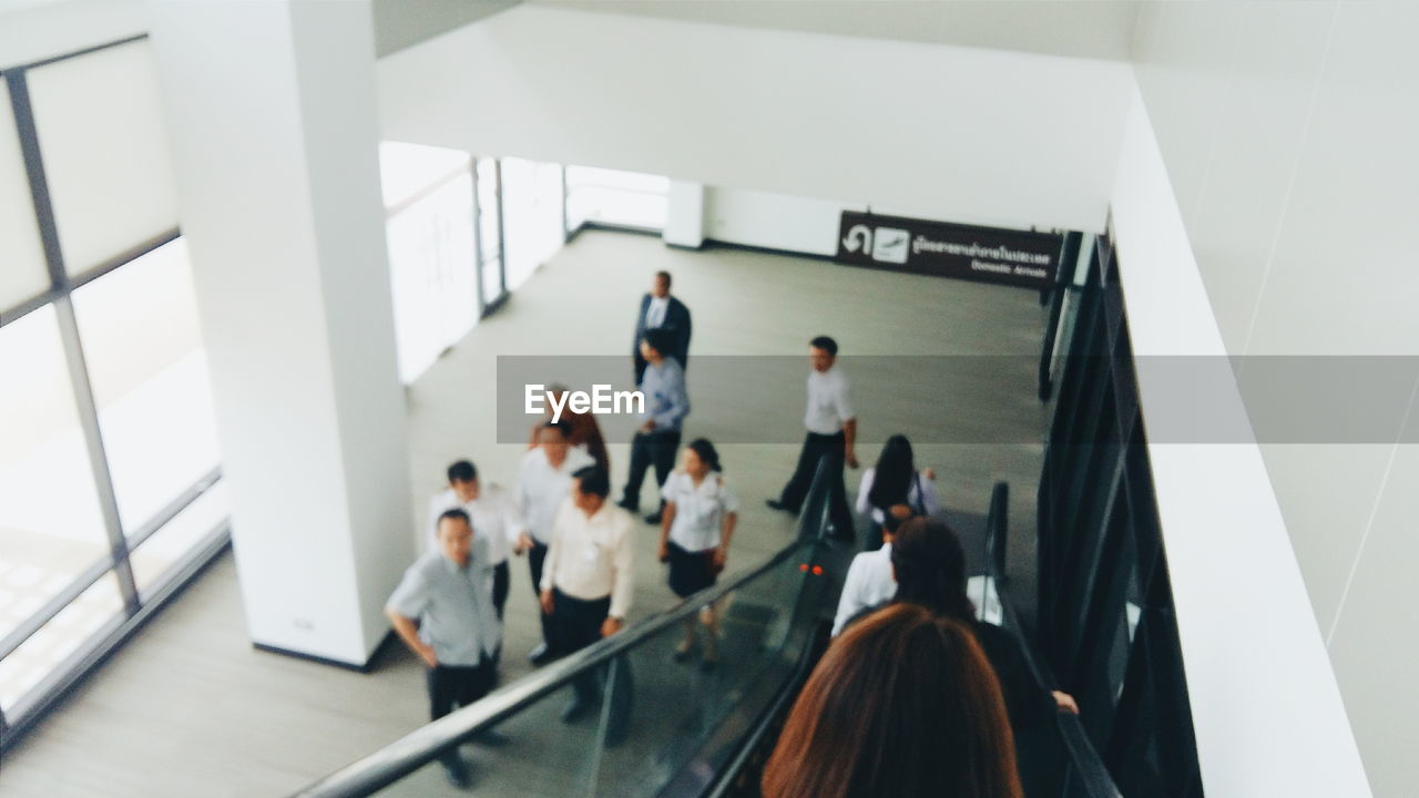 High angle view of people by escalator in modern building