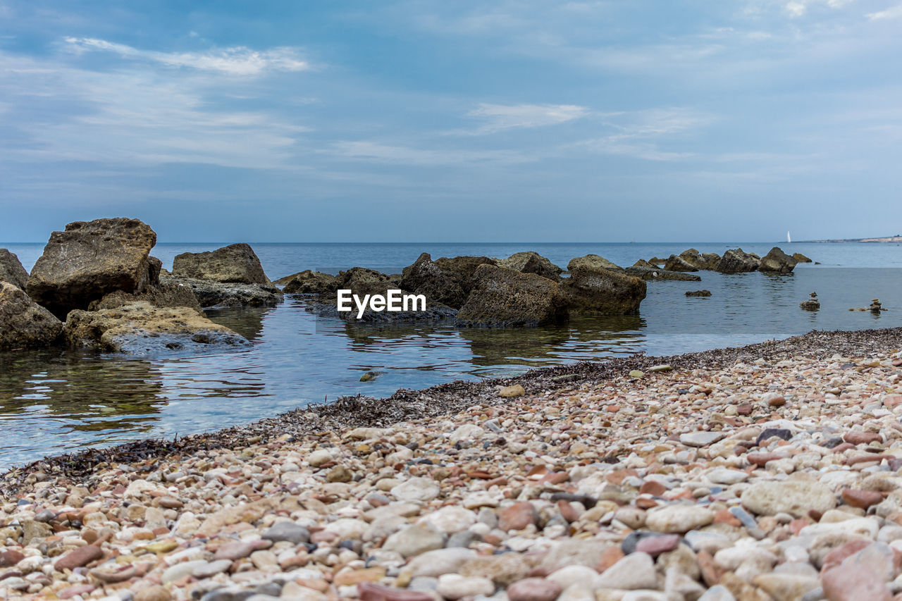 Rocks in sea against sky