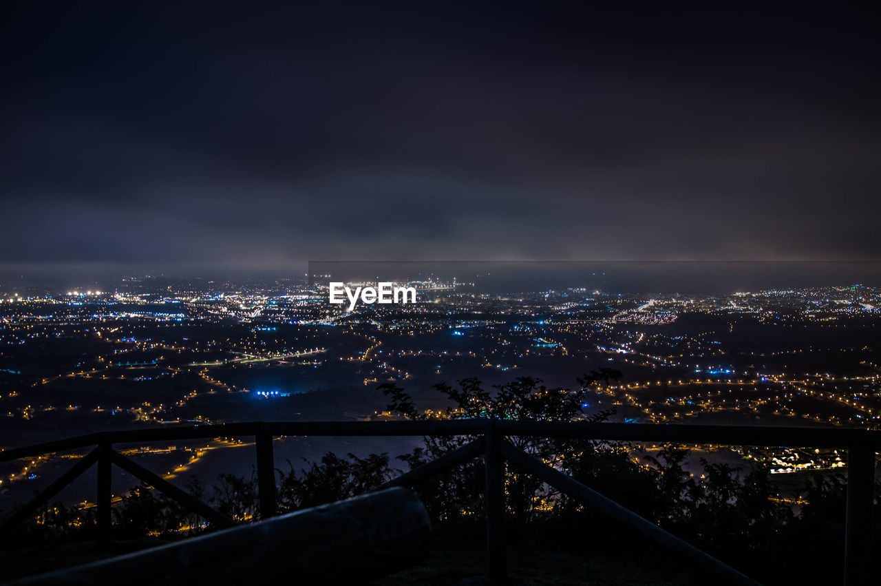 Illuminated cityscape against sky at night