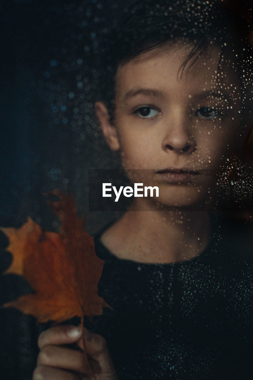 Close-up portrait of young boy looking away