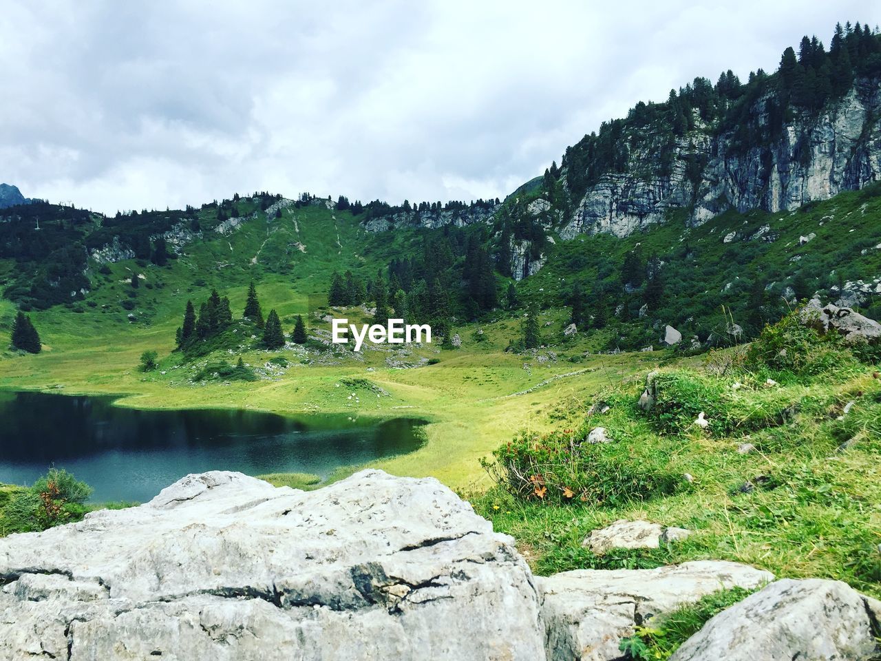 Scenic view of lake by mountain against sky