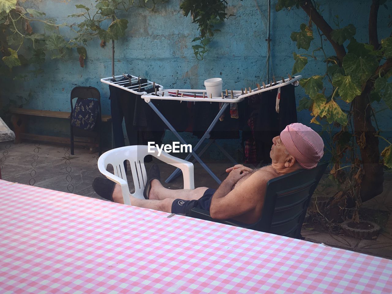 REAR VIEW OF MAN SITTING AT TABLE AT RESTAURANT