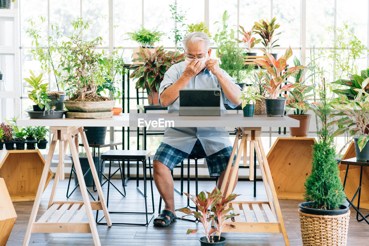 Full length of man sitting on table