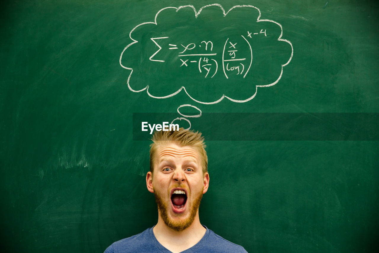 Man shouting with mathematical formula on blackboard