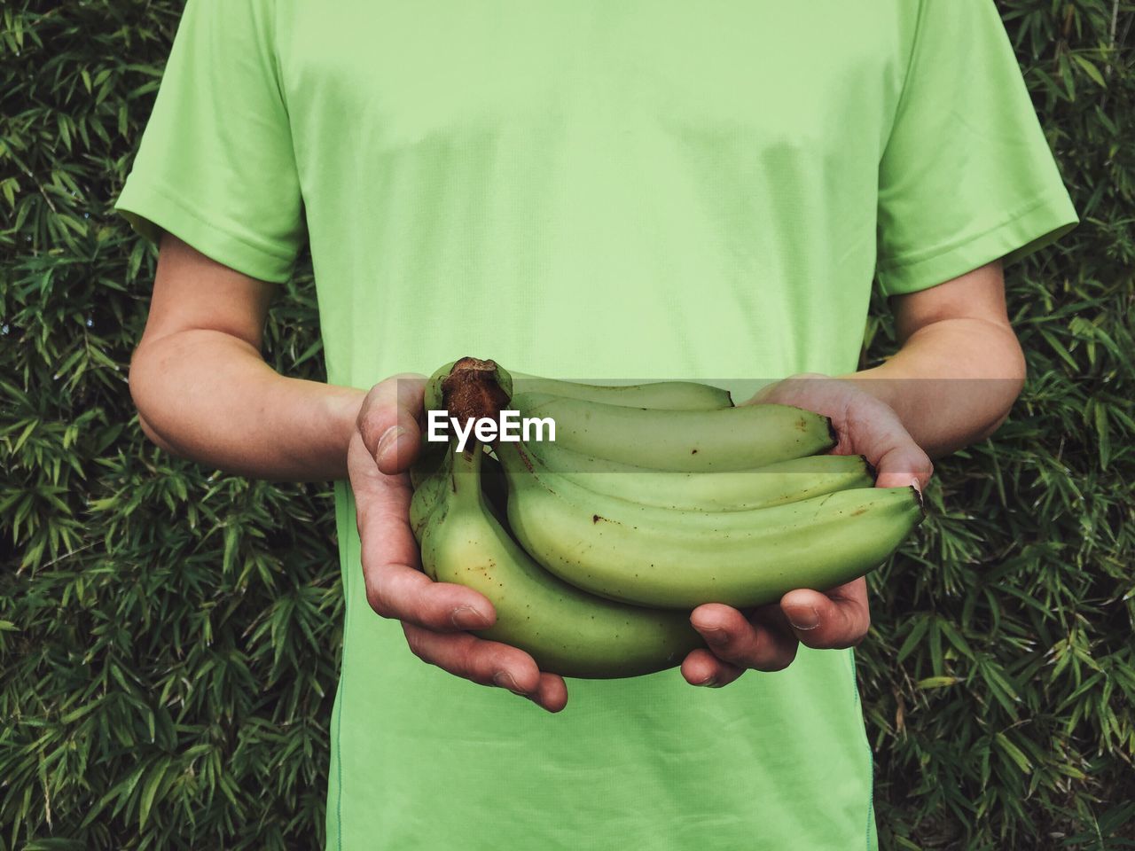 High angle view of man holding apple while standing on field