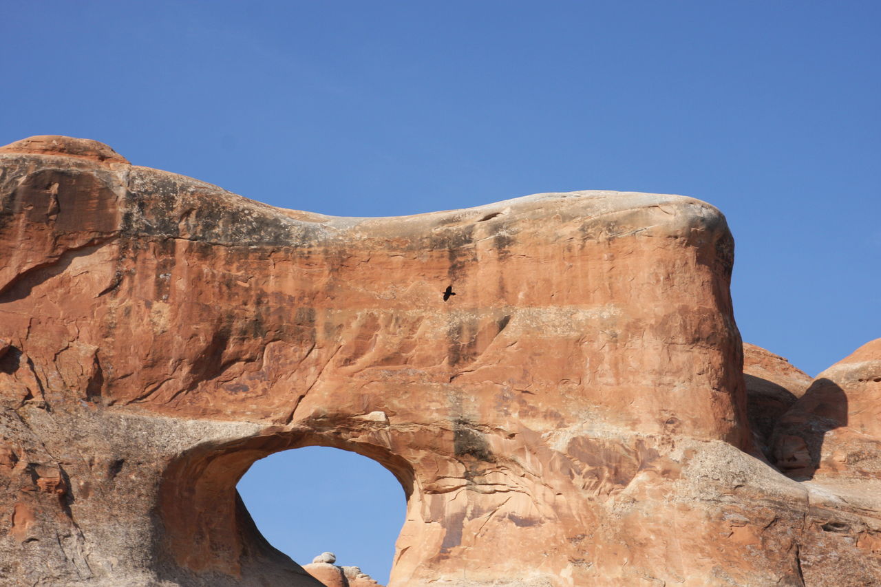 LOW ANGLE VIEW OF ROCK FORMATIONS AGAINST CLEAR BLUE SKY