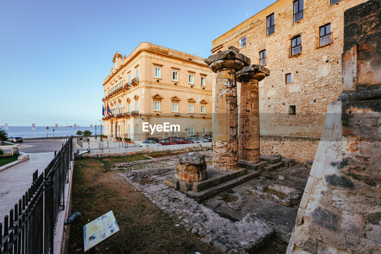 architecture, built structure, building exterior, ancient history, town, history, sky, the past, travel destinations, clear sky, nature, city, water, travel, tourism, ruins, building, wall, old, urban area, landmark, no people, ancient, day, blue, outdoors, sunny, fortification