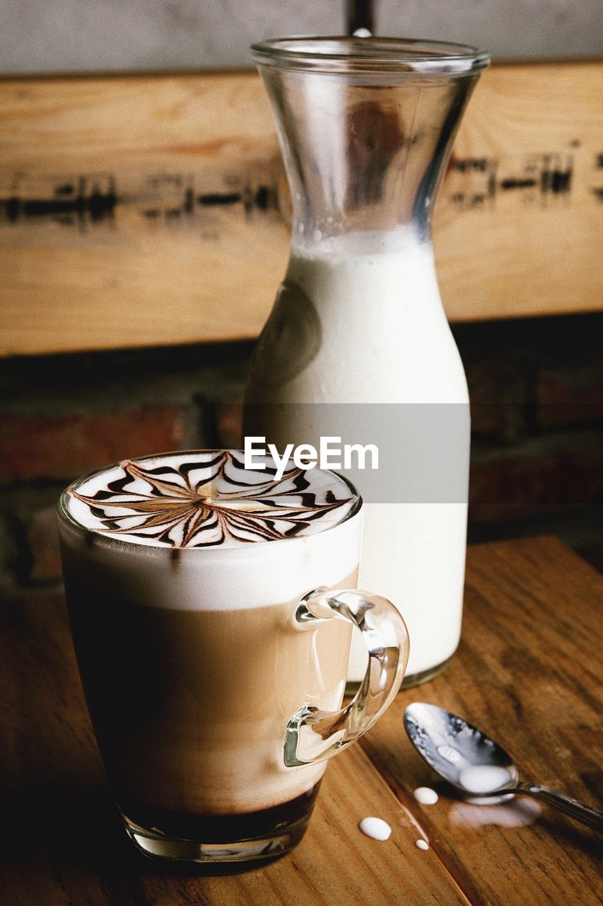 Latte coffee with milk in bottle on table