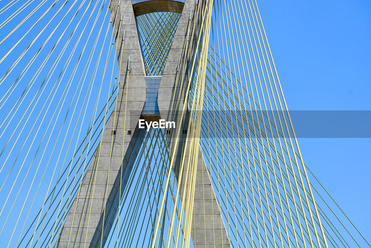 Low angle view of suspension bridge against sky