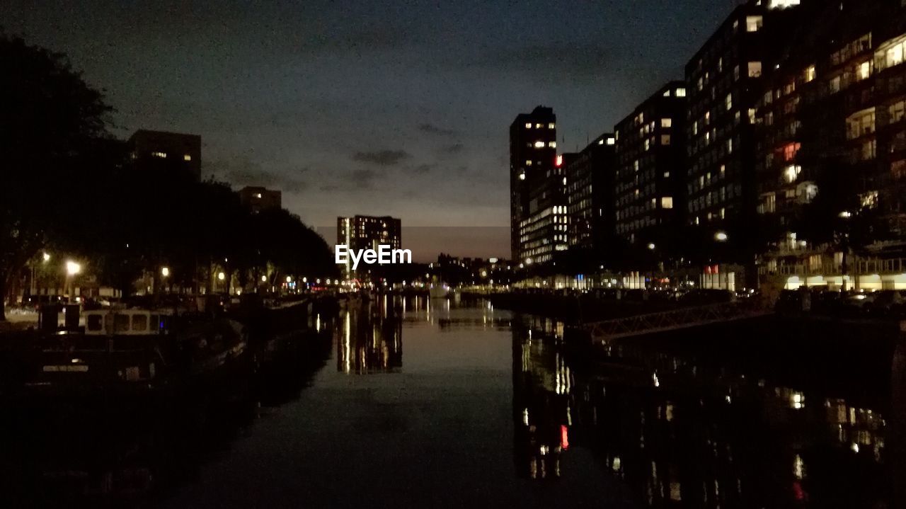 REFLECTION OF ILLUMINATED BUILDINGS IN WATER AT NIGHT