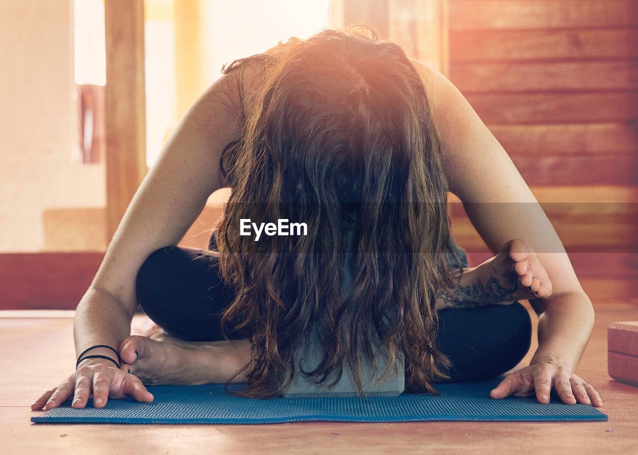 Woman with long hair doing yoga at home