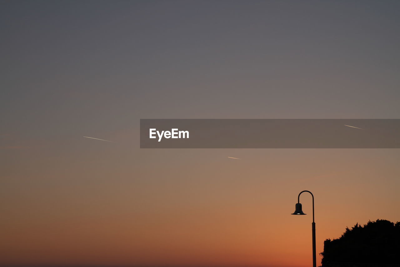 Silhouette of street light against clear sky