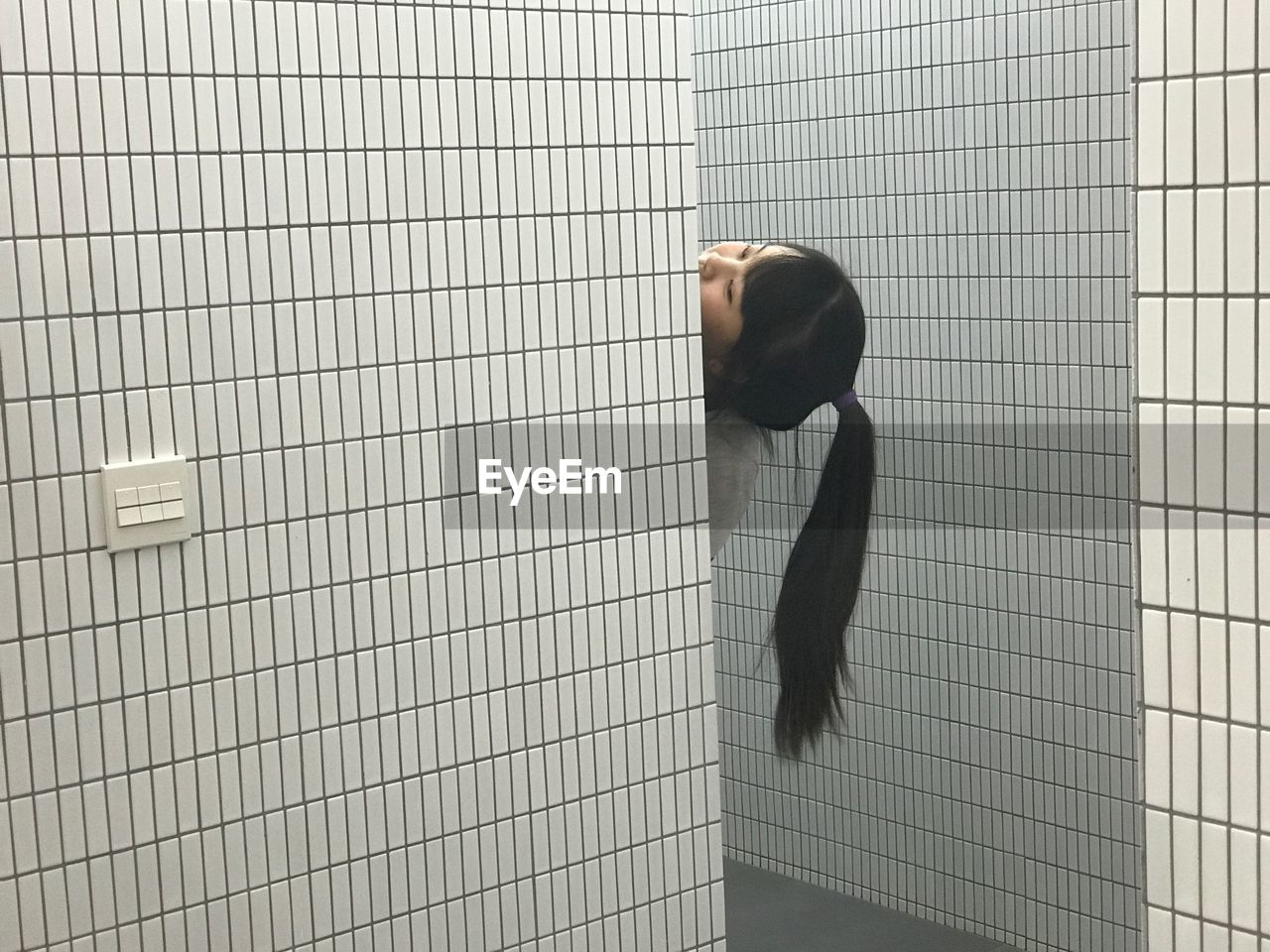 Cropped image of woman by wall in bathroom