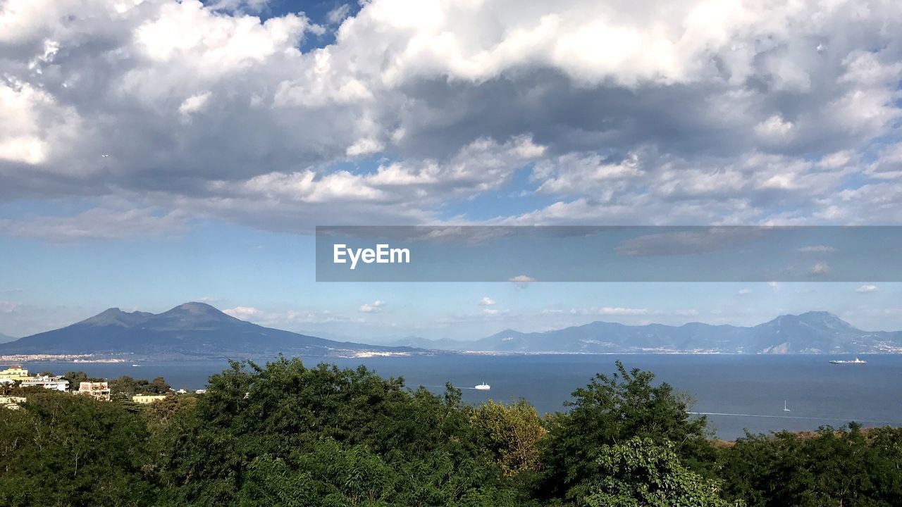 Scenic view of sea and mountains against sky