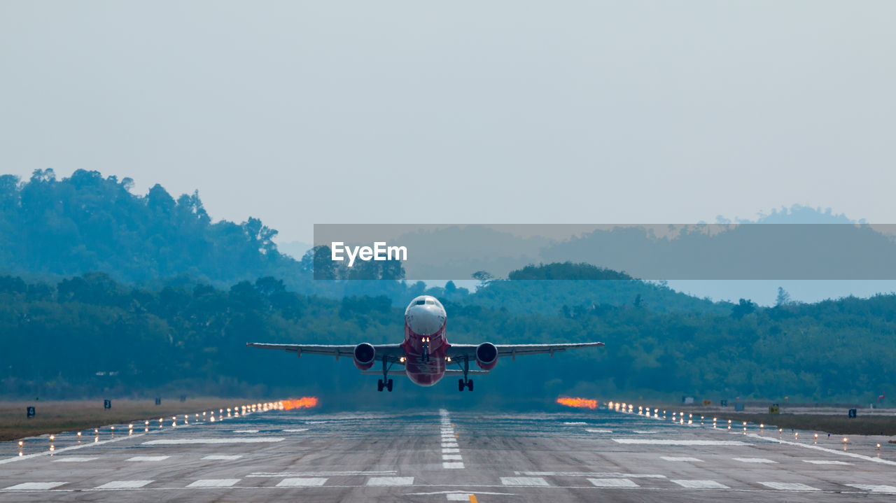 Airplane taking off on runway against sky