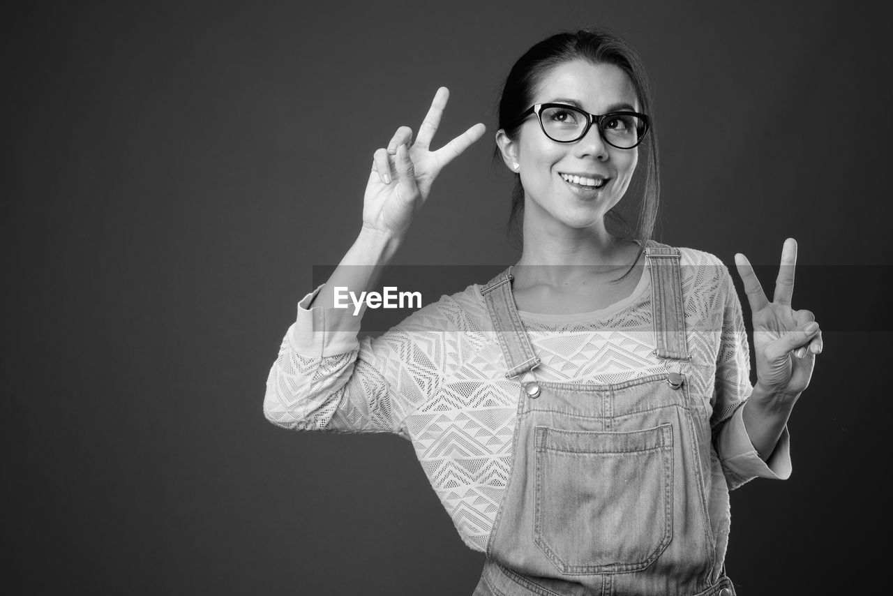 Smiling woman standing against black background