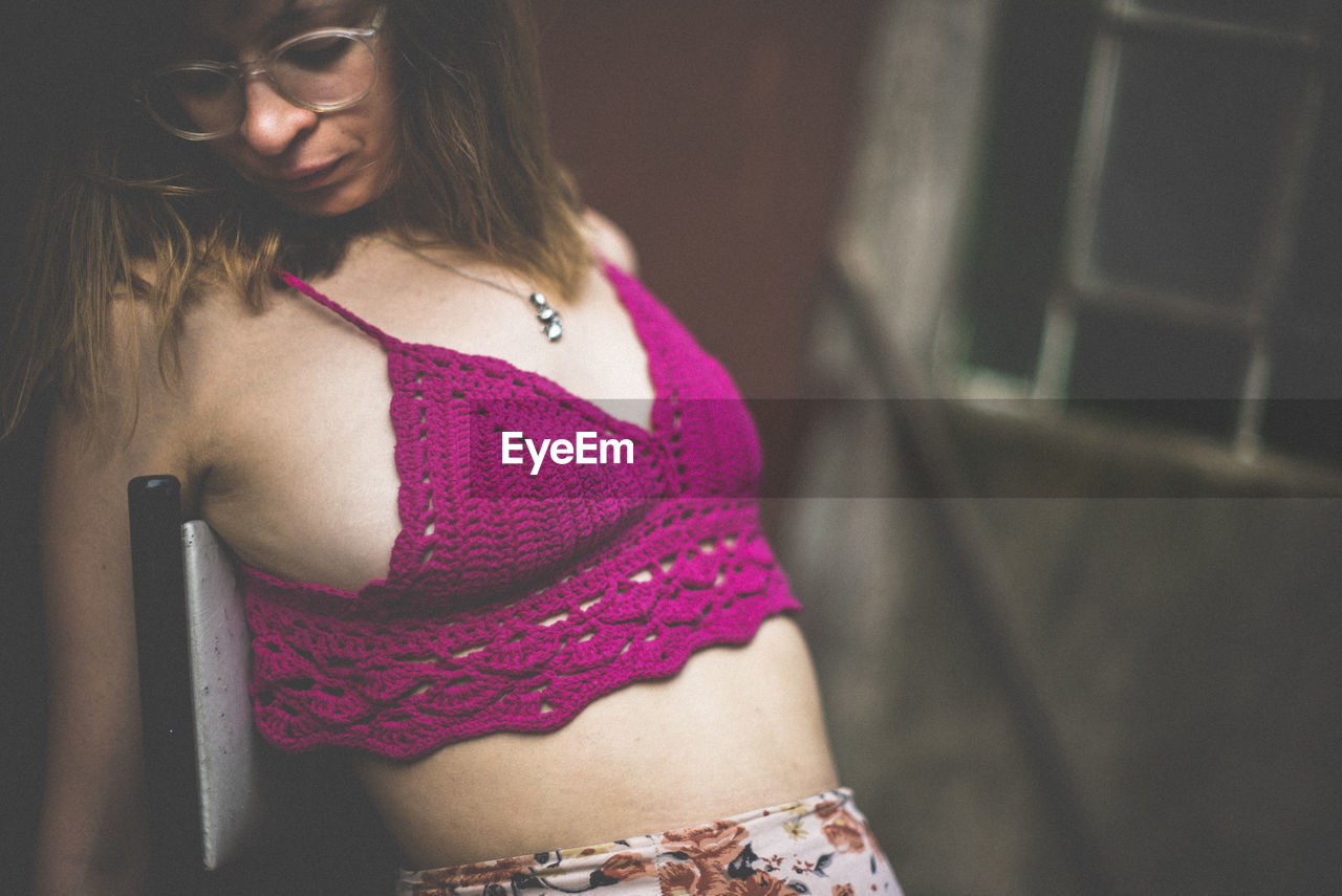 Close-up of young woman wearing bra at home