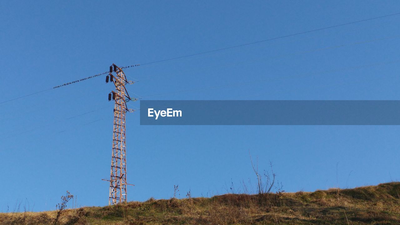 LOW ANGLE VIEW OF ELECTRICITY PYLON AGAINST BLUE SKY