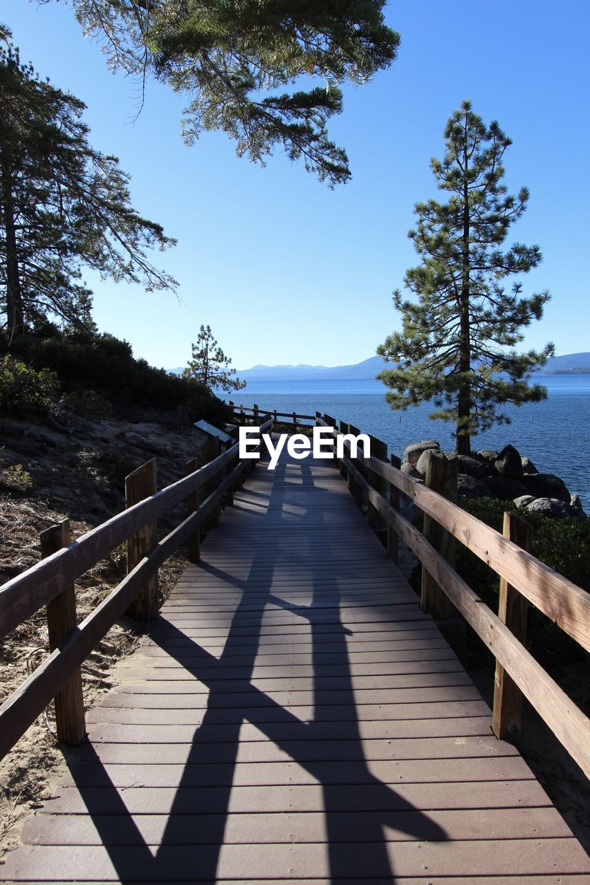 View of footpath by sea against clear sky