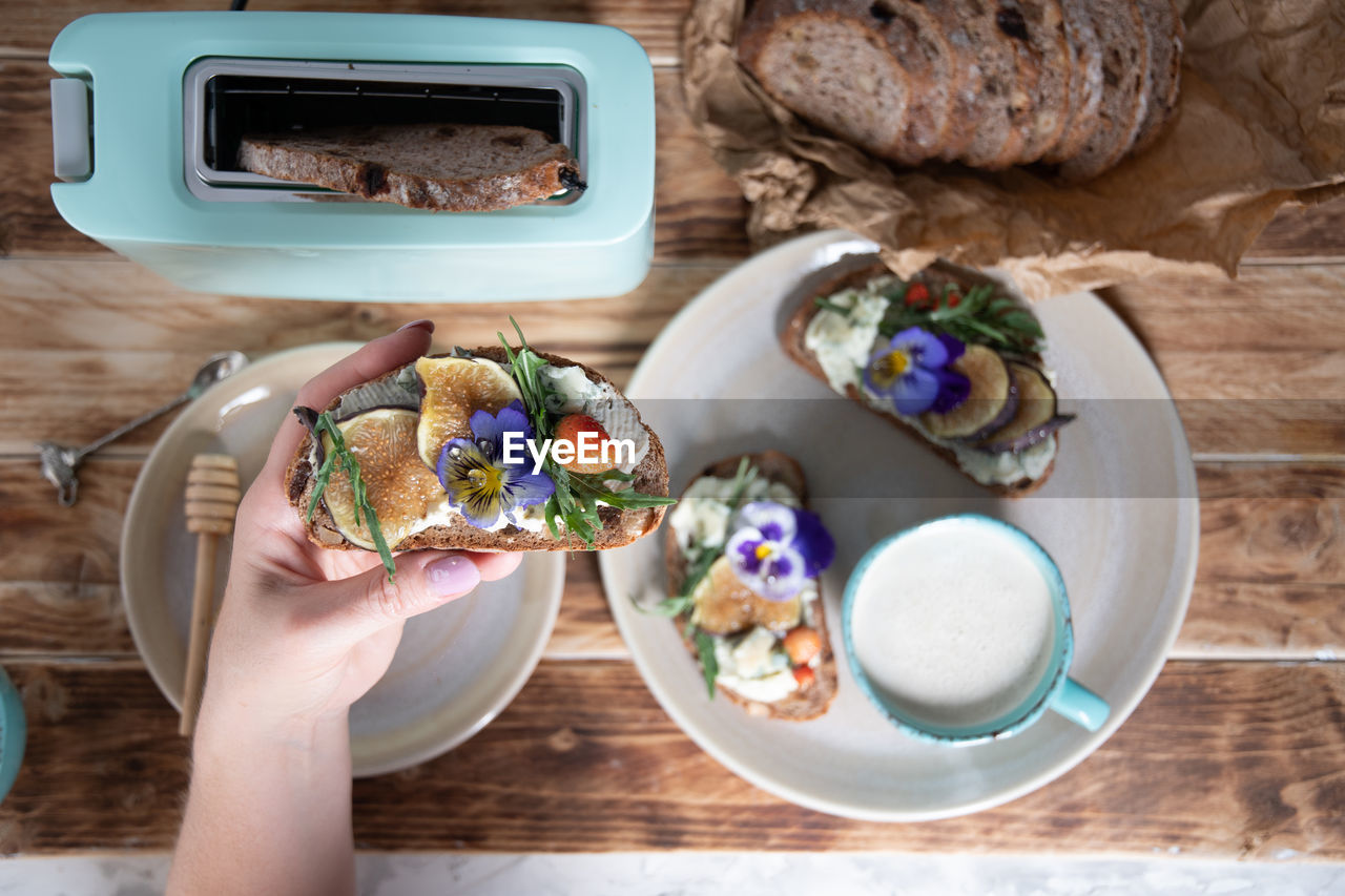 Delicious bruschetta with homemade bread, garnished with fig,soft cheese,pansies