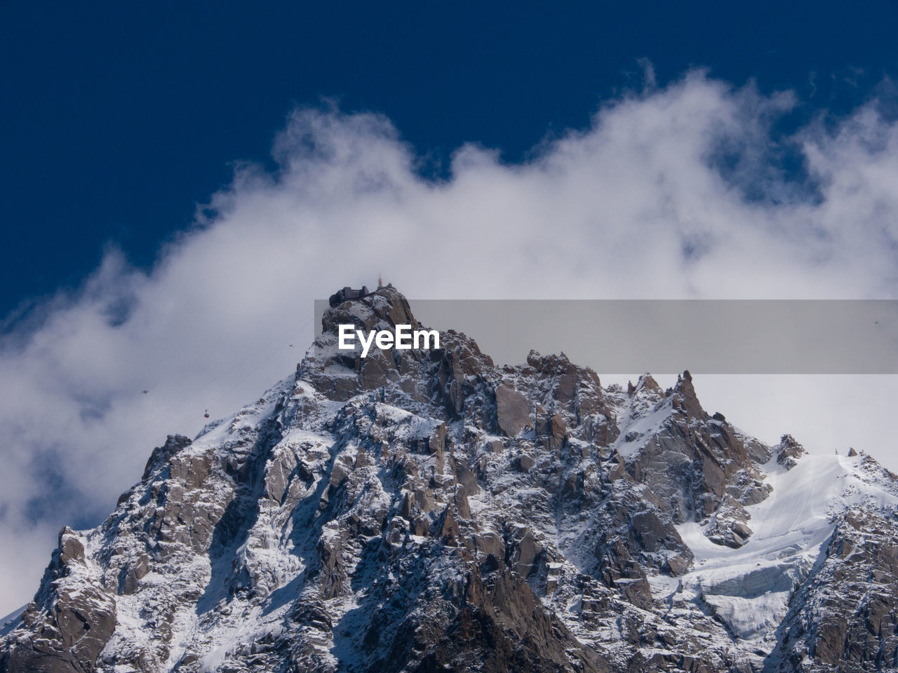 Low angle view of mountain against cloudy sky