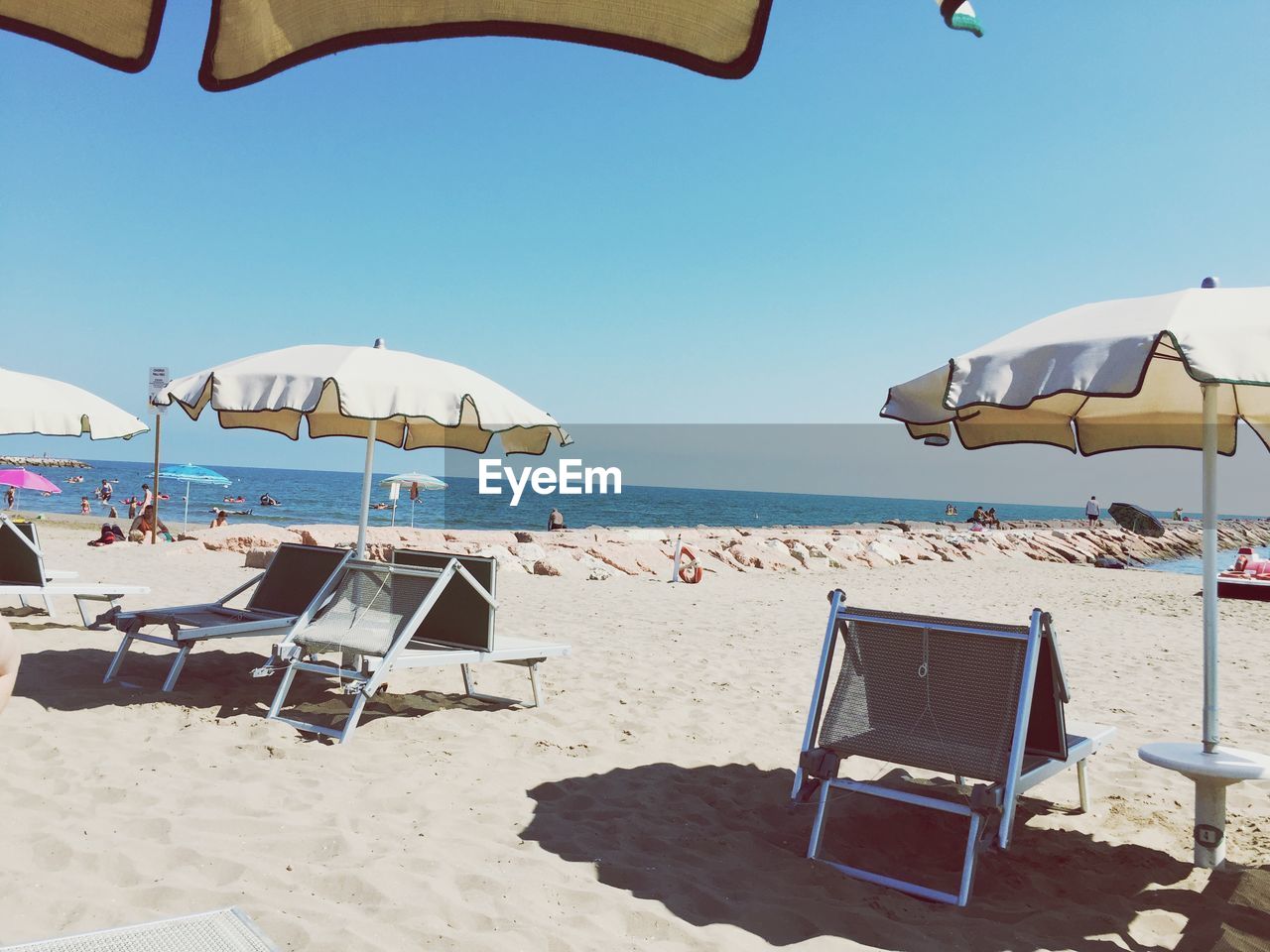 People enjoying summer at beach against sky