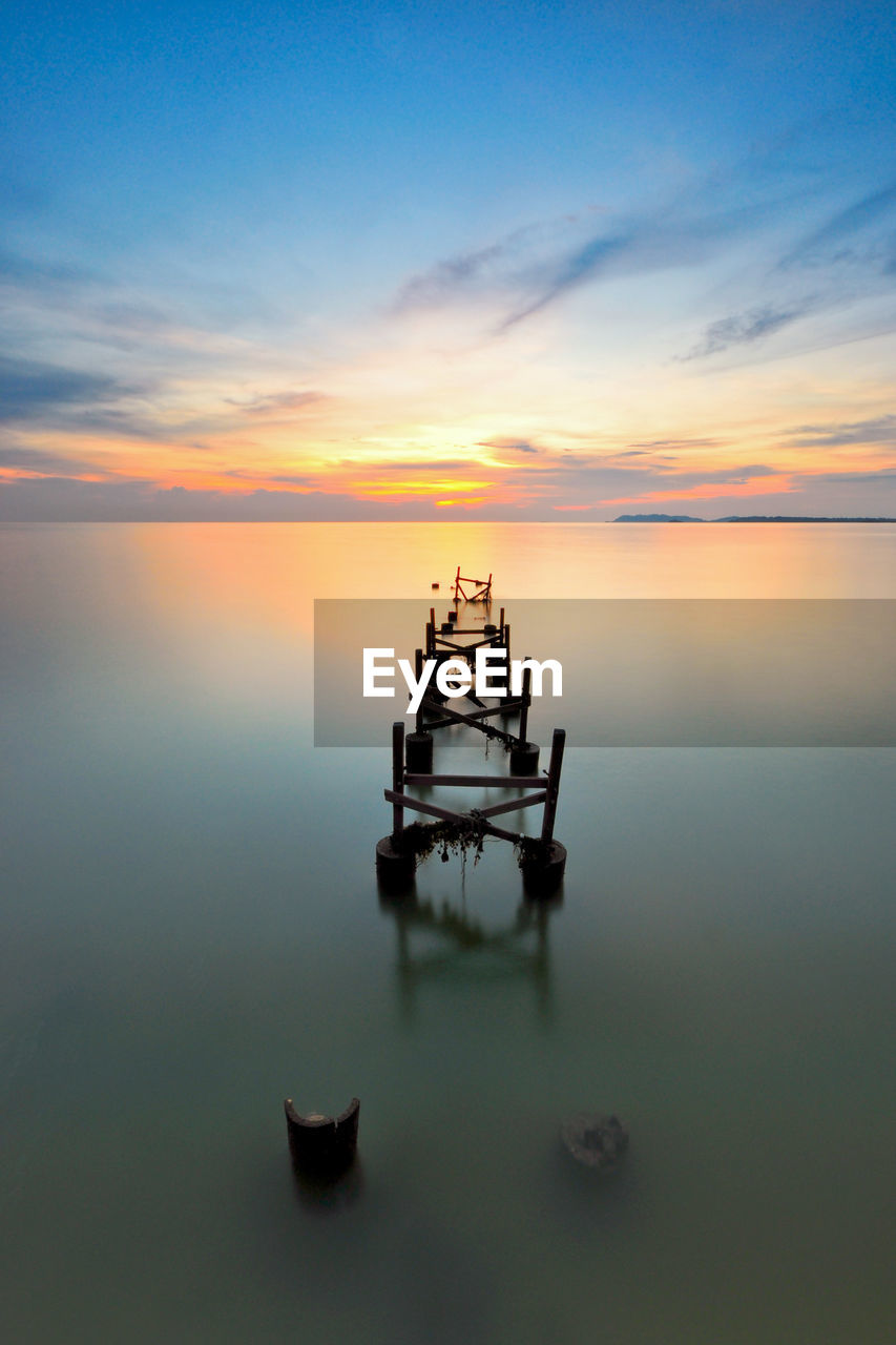 High angle view of broken pier over sea during sunset