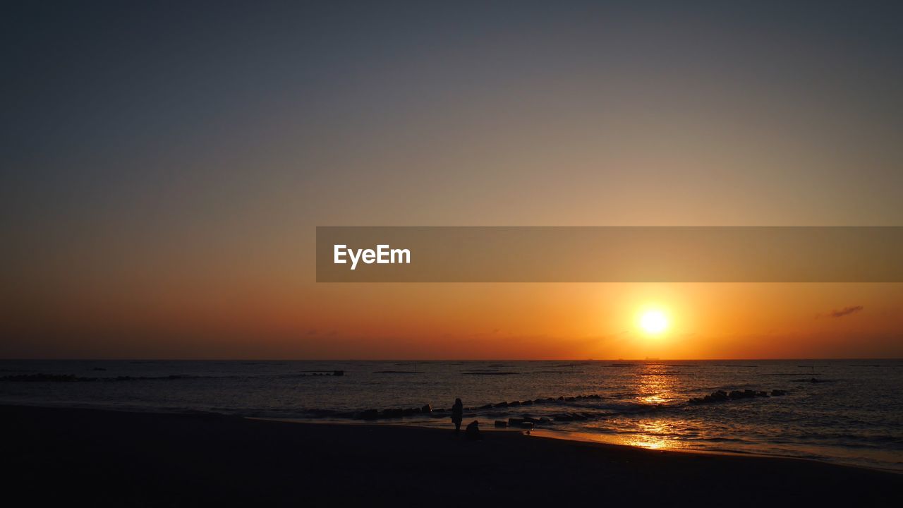 SCENIC VIEW OF BEACH AGAINST SKY DURING SUNSET