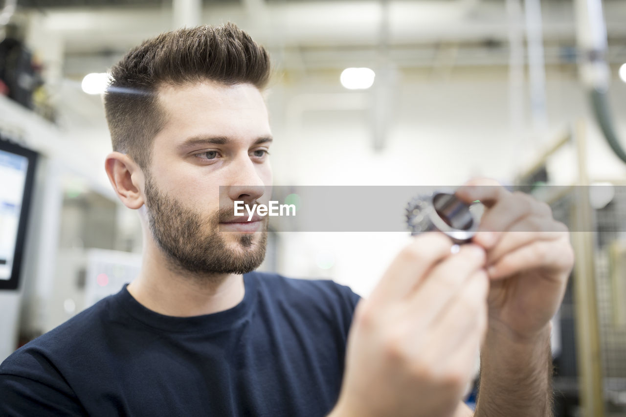 Man examining workpiece in a factory