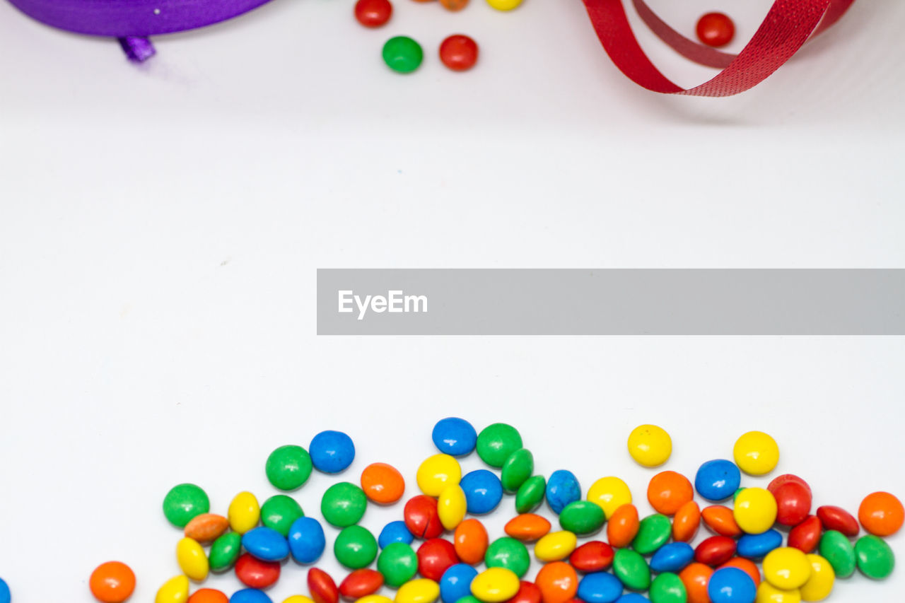 HIGH ANGLE VIEW OF MULTI COLORED CANDIES ON TABLE