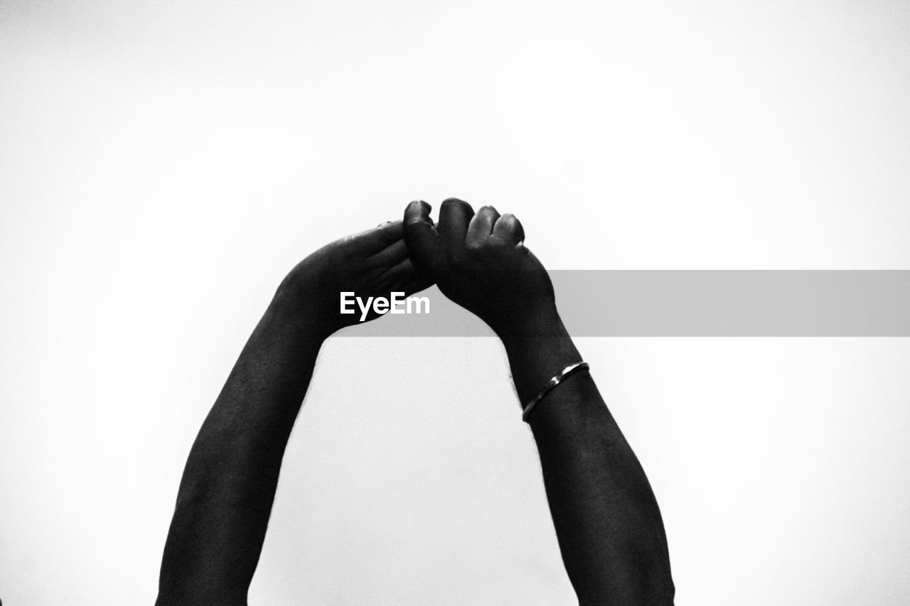 CLOSE-UP OF WOMAN HAND AGAINST GRAY BACKGROUND