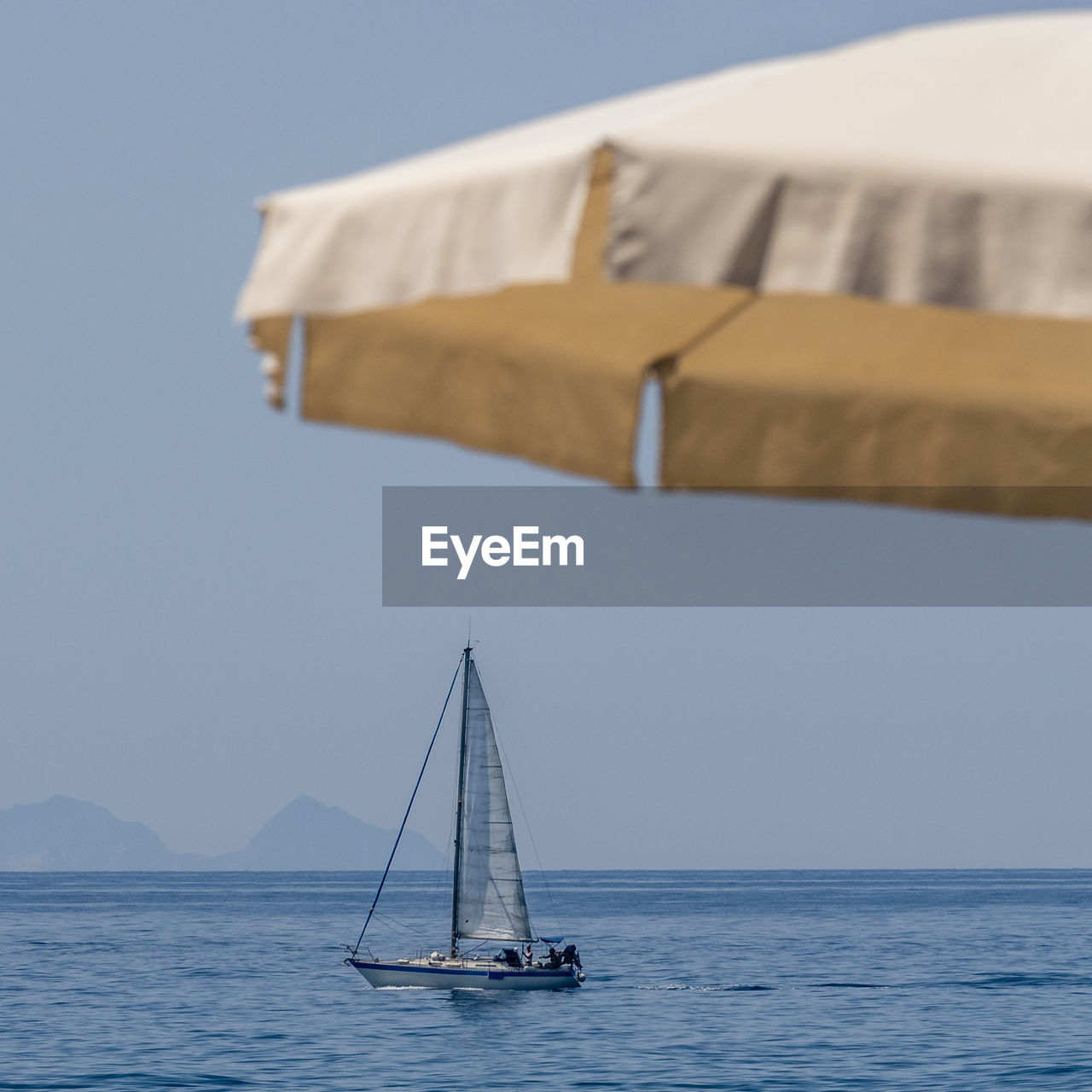 Sailboat sailing on sea against clear sky