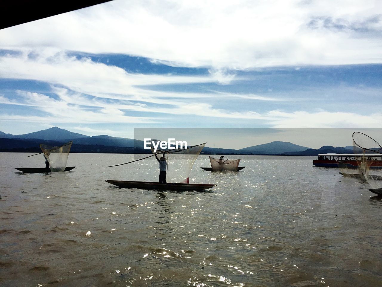 Boats in sea with mountain range in background