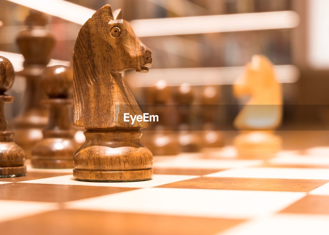 CLOSE-UP OF CHESS PIECES ON TABLE AT HOME