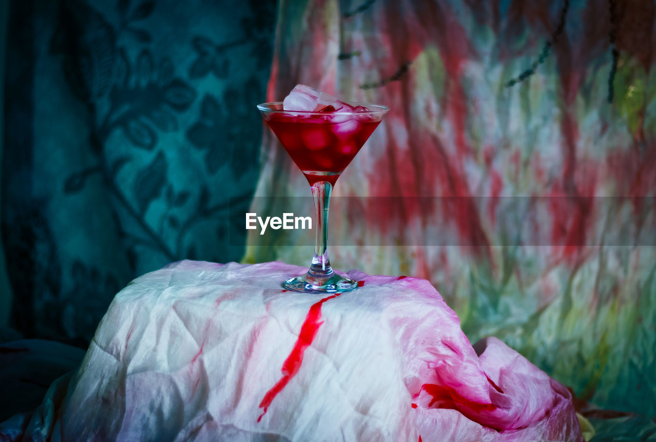 Cropped hand of woman holding wineglass on table