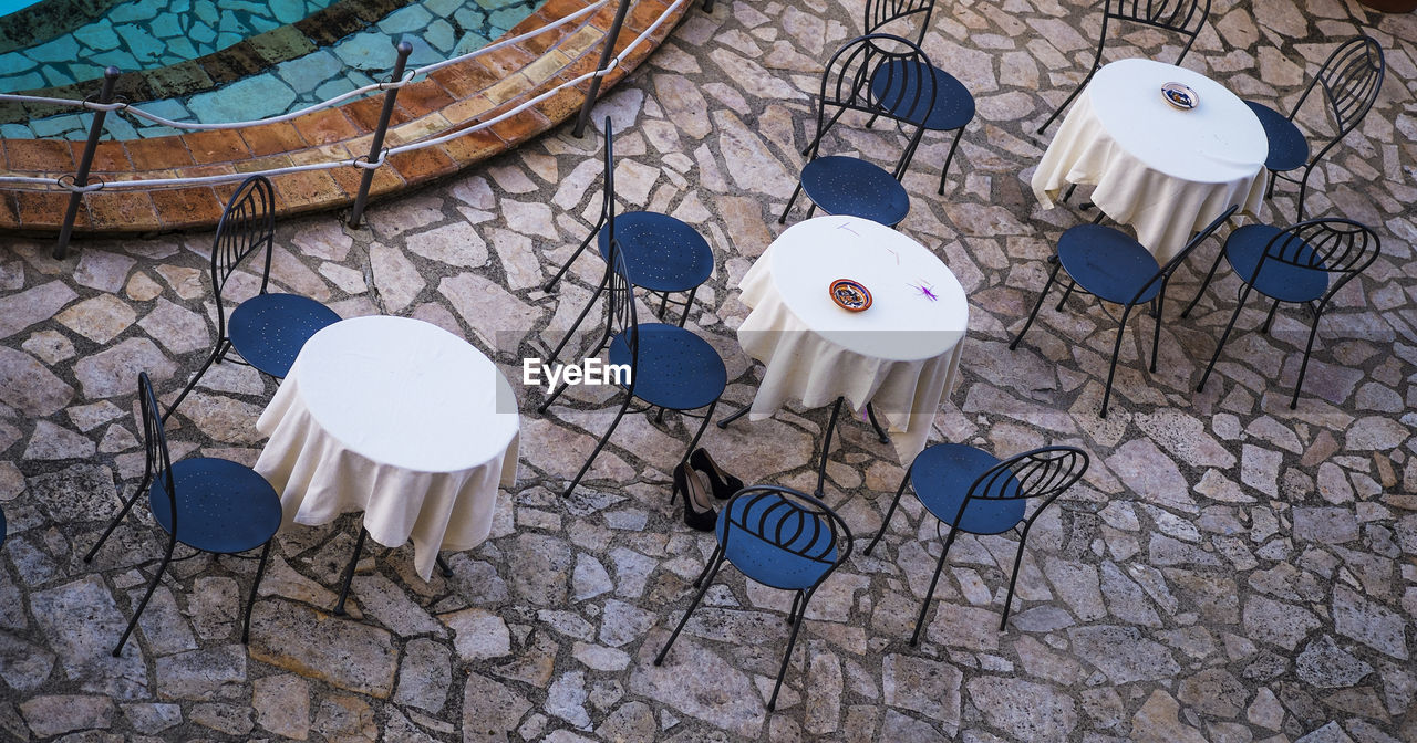 HIGH ANGLE VIEW OF CHAIRS ON TABLE AGAINST BLUE SKY