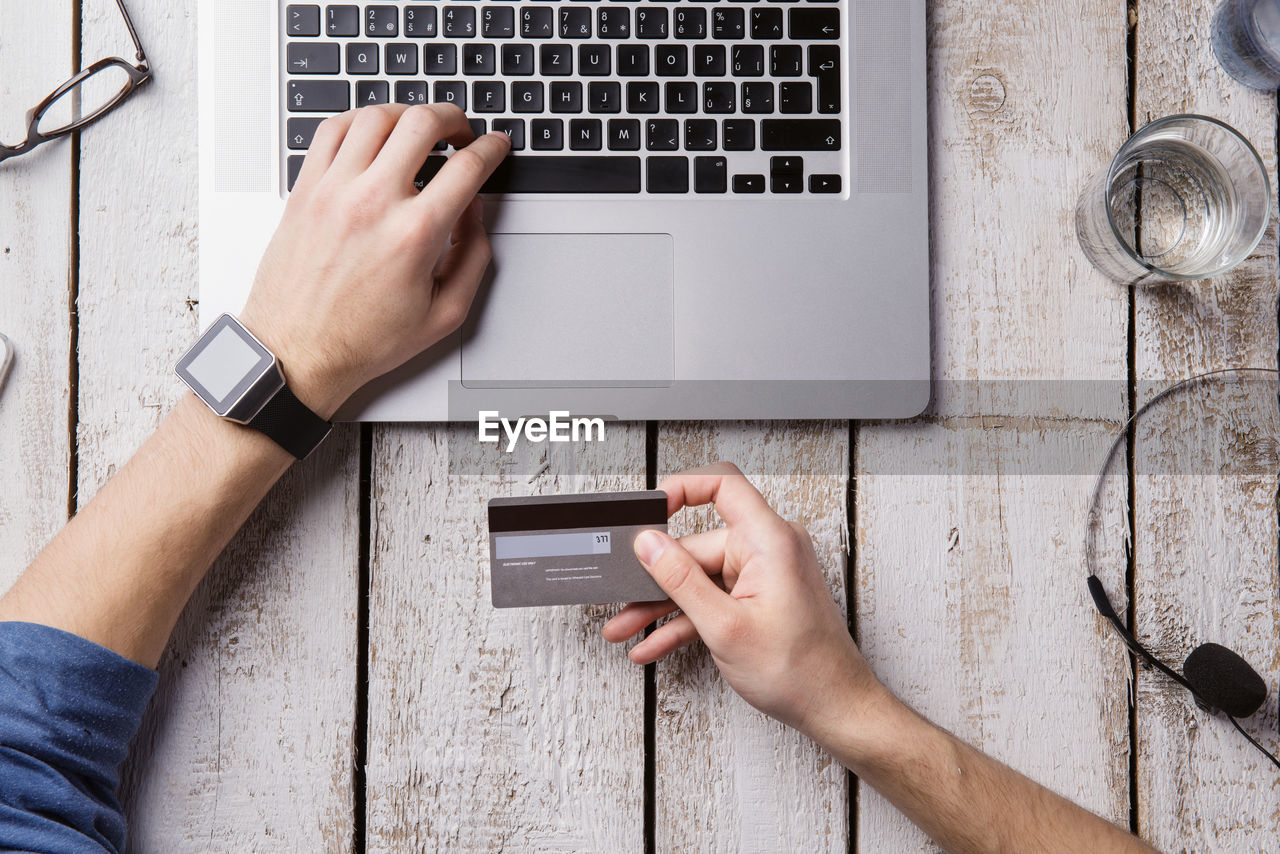 Man sitting at desk paying online with credit card