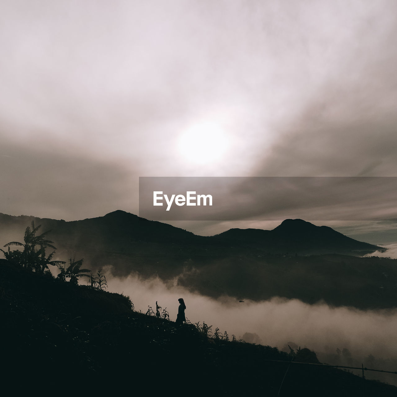 Silhouette people standing on mountain against sky