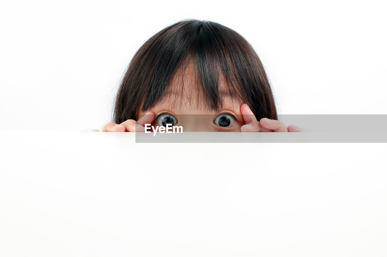 Close-up portrait of a funny child against white background