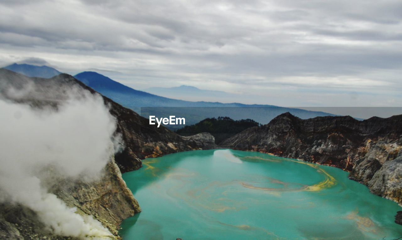 PANORAMIC VIEW OF MOUNTAIN RANGE AGAINST CLOUDY SKY