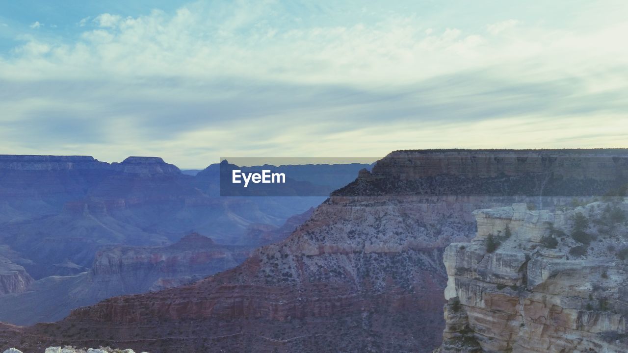 SCENIC VIEW OF MOUNTAINS AGAINST CLOUDY SKY